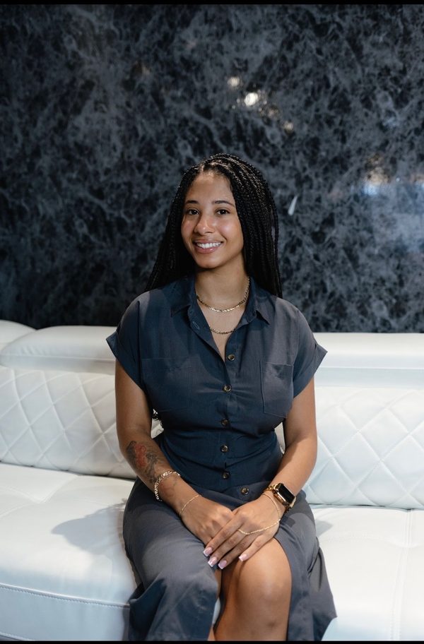 Lena Claire, healthy-habits coach, smiling in a slate-blue shirt dress